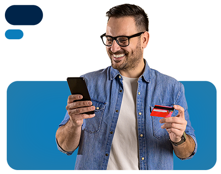 Hombre sonrriendo mientras revisa su celular y tarjeta debito.